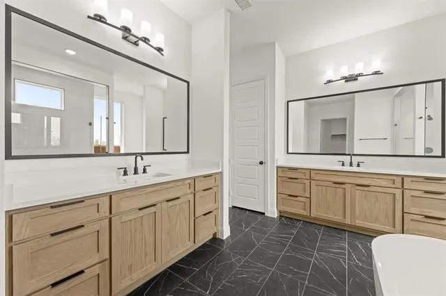 a spacious bathroom with a granite countertop sink a mirror a vanity and a