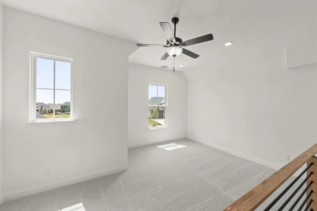 an empty room with windows and fan