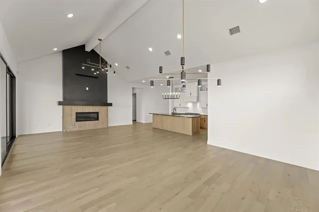 a view of kitchen with refrigerator and white cabinets