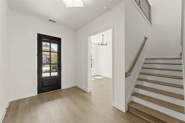 a view of an entryway with wooden floor and door