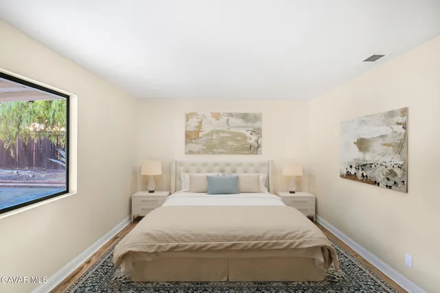 a bedroom with a bed and a painting on the wall