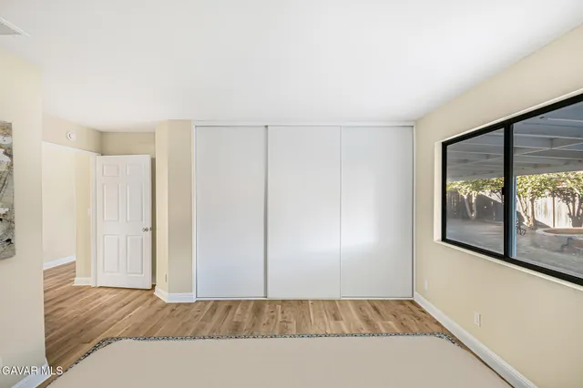 a view of a room with wooden floor and a window