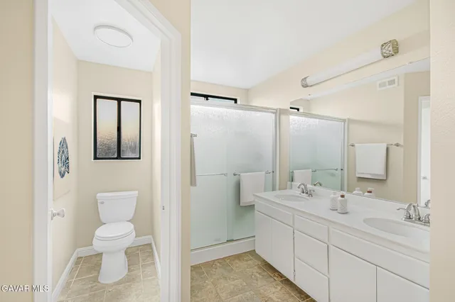 a bathroom with a double vanity sink mirror and toilet