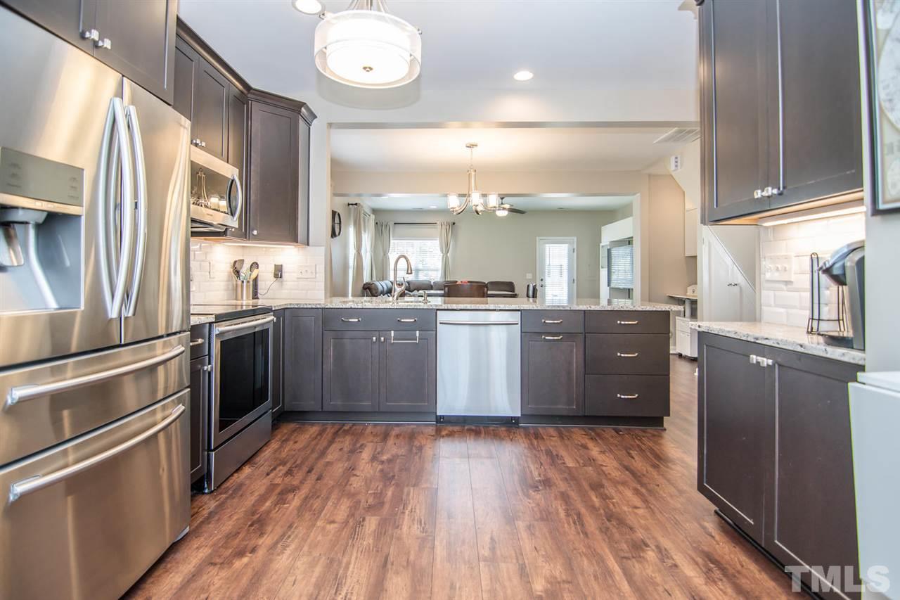 107 Eldon Lane Apex, NC 27502 - Photo 5 of 29 42" cabinets--Espresso Maple, full-extension drawers, dove tail, soft close, deep drawers, message center, lazy susans, granite counters, tile backsplash, stainless steel appliances, under counter lighting, undermount sink with pull-out sprayer.
