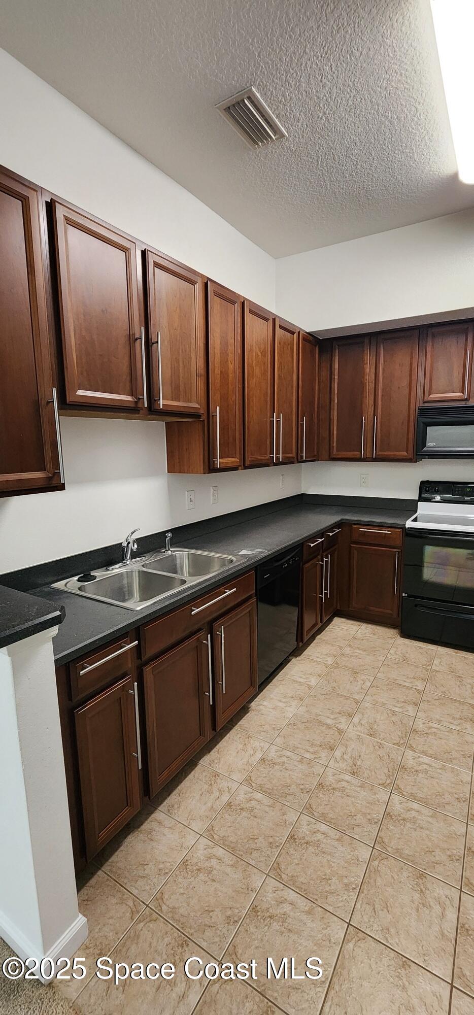 4076 Meander Place, Unit 103 Rockledge, FL 32955 - Photo 8 of 24 a large kitchen with stainless steel appliances granite countertop a sink stove and cabinets