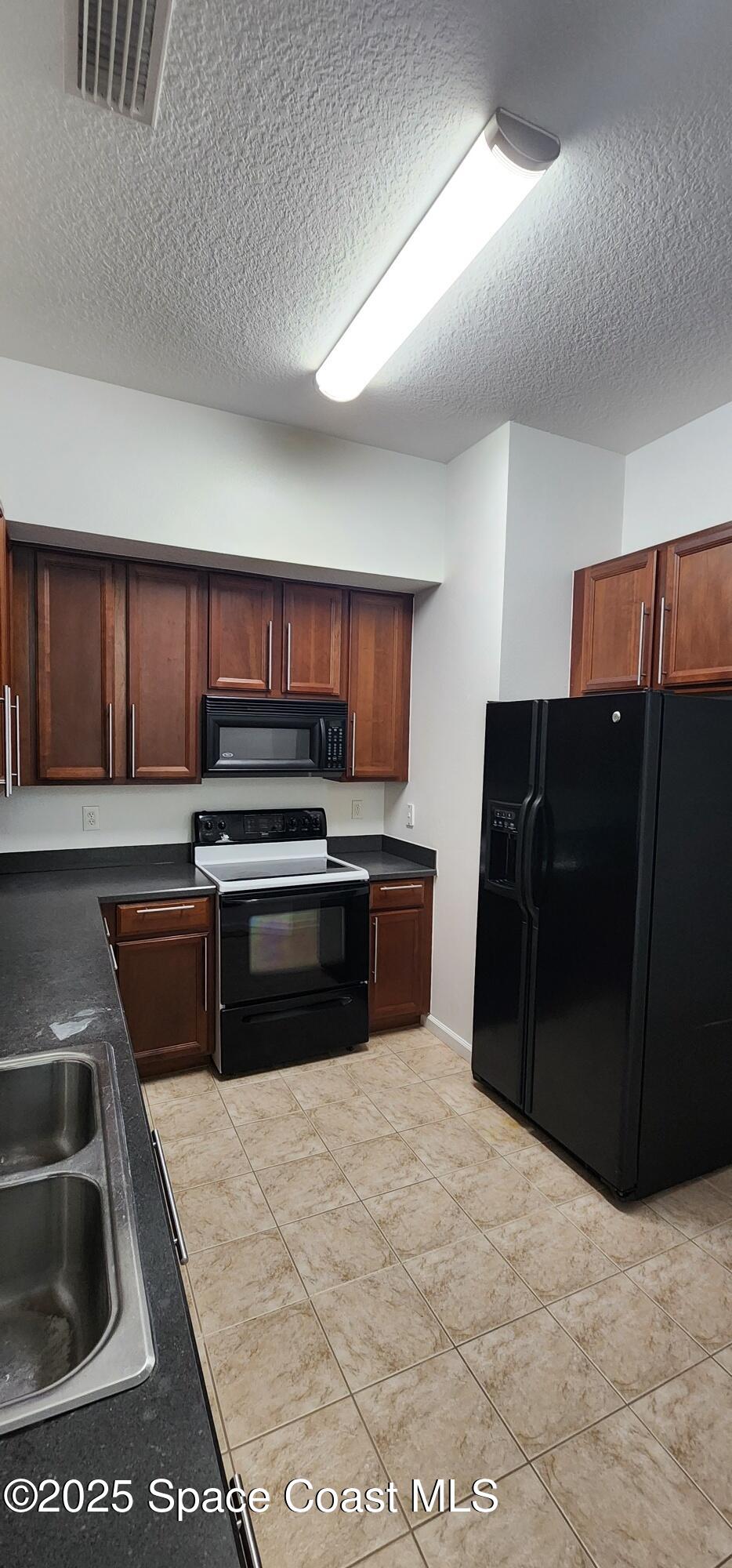 4076 Meander Place, Unit 103 Rockledge, FL 32955 - Photo 9 of 24 a kitchen with a refrigerator and a sink