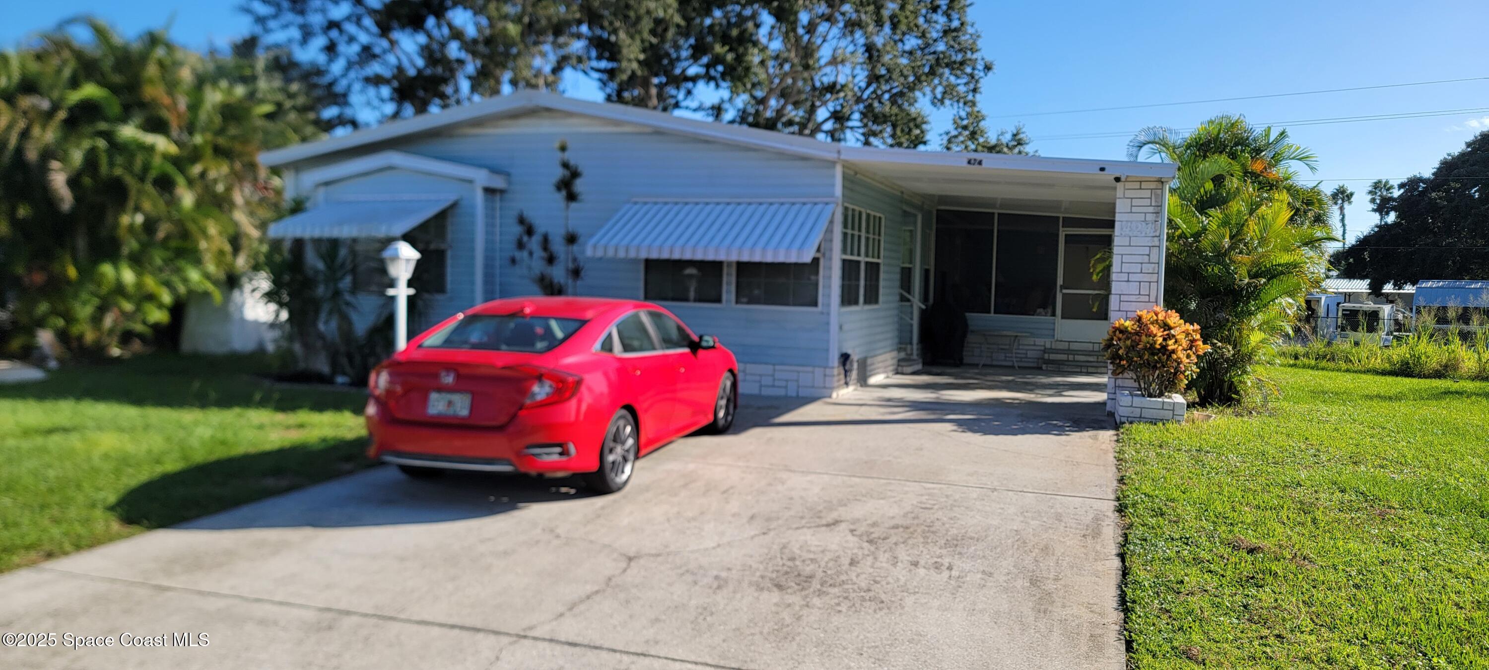 a front view of a house with a garden and trees