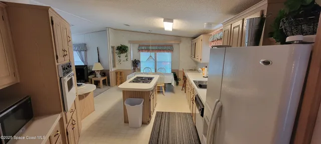 a view of a kitchen with furniture and a refrigerator