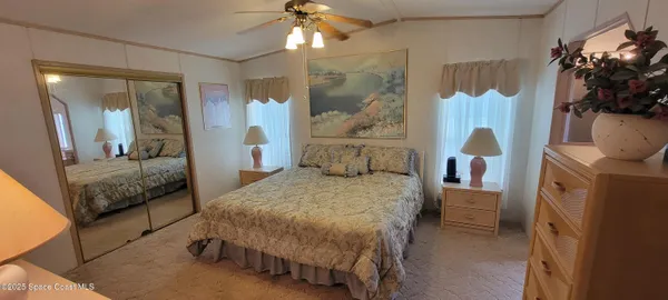 a bedroom with a bed and a mirror on dresser