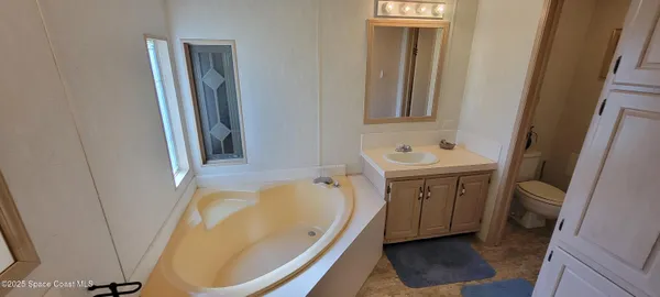 a bathroom with a tub sink and mirror
