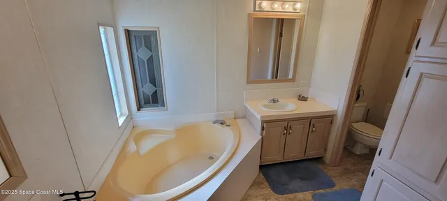 a bathroom with a tub sink and mirror