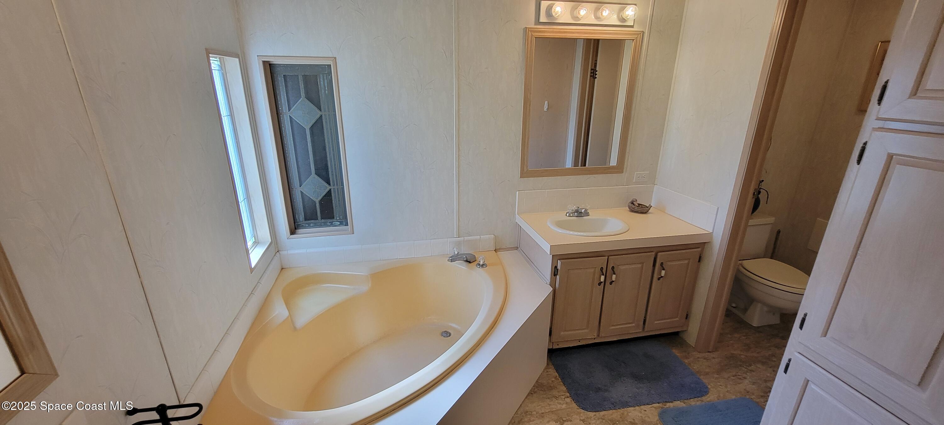 474 Marlin Circle Barefoot Bay, FL 32976 - Photo 8 of 14 a bathroom with a tub sink and mirror