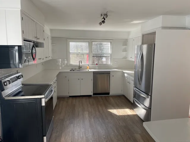 a kitchen with stainless steel appliances granite countertop a sink stove and refrigerator
