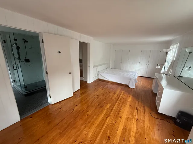 a view of a living room with wooden floor and a ceiling fan