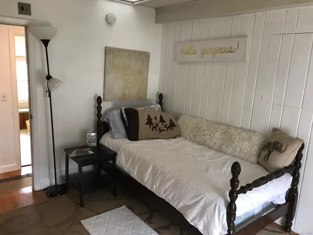 a bedroom with a bed and wooden floor
