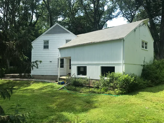 a backyard of a house with potted plants and large tree