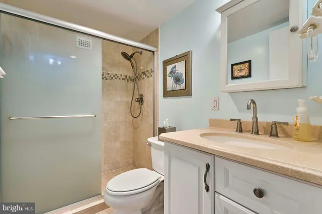 a bathroom with a granite countertop sink toilet and shower
