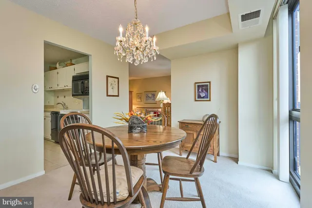a view of a dining room with furniture and chandelier