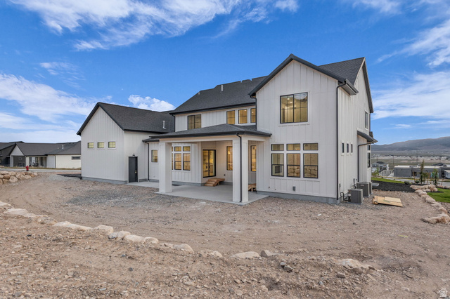 2828 Jojo Road Eagle Mountain, UT 84005 - Photo 49 of 63 Modern farmhouse exterior featuring white vertical siding and dark-trimmed windows