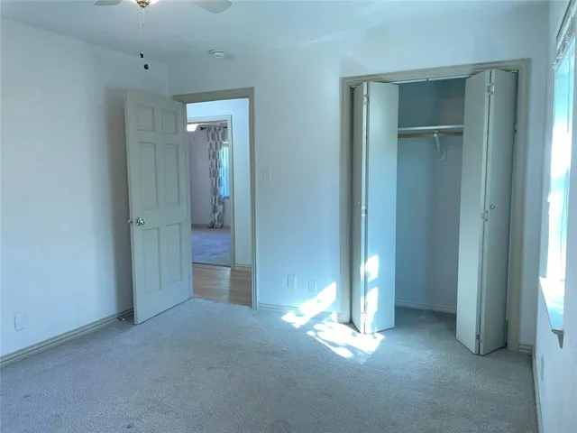 an empty room with windows and closet