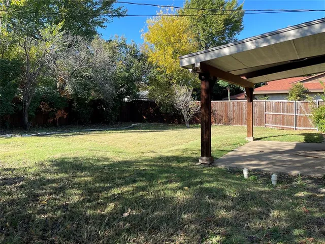 a view of a patio with a table and chairs under an umbrella