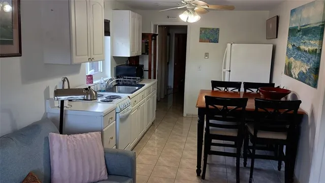 a kitchen with stainless steel appliances granite countertop a stove a refrigerator a sink a table and chairs