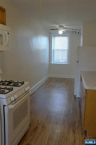 a kitchen with a stove wooden floor and a window