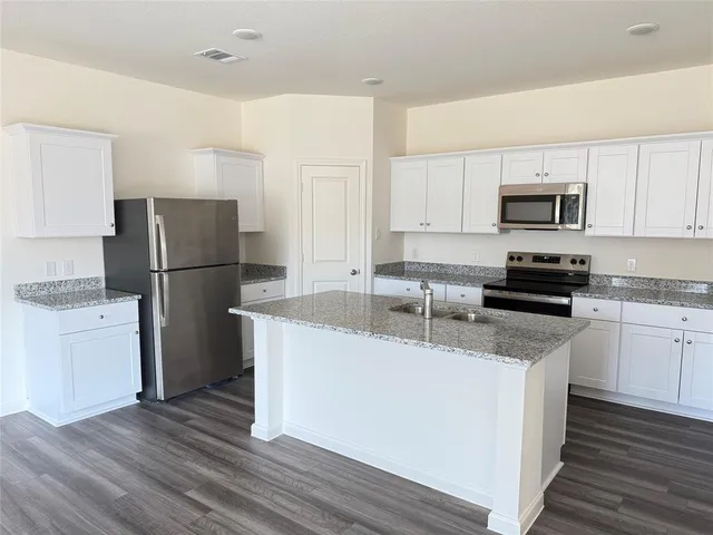 a kitchen with a refrigerator and a stove top oven