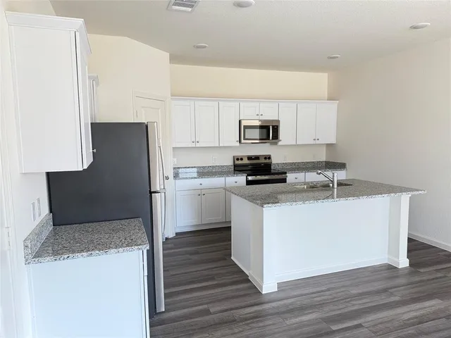 a kitchen with stainless steel appliances a refrigerator stove microwave and sink