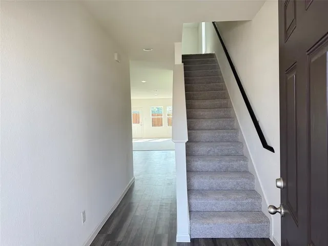 a view of staircase with wooden floor and white walls