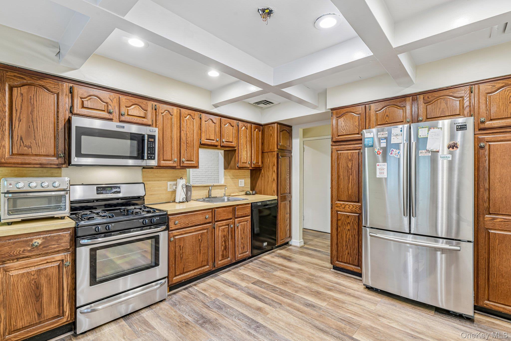237 Cedar Road East Northport, NY 11731 - Photo 12 of 45 Gas stove, Stainless steel appliances. Wood look vinyl flooring.