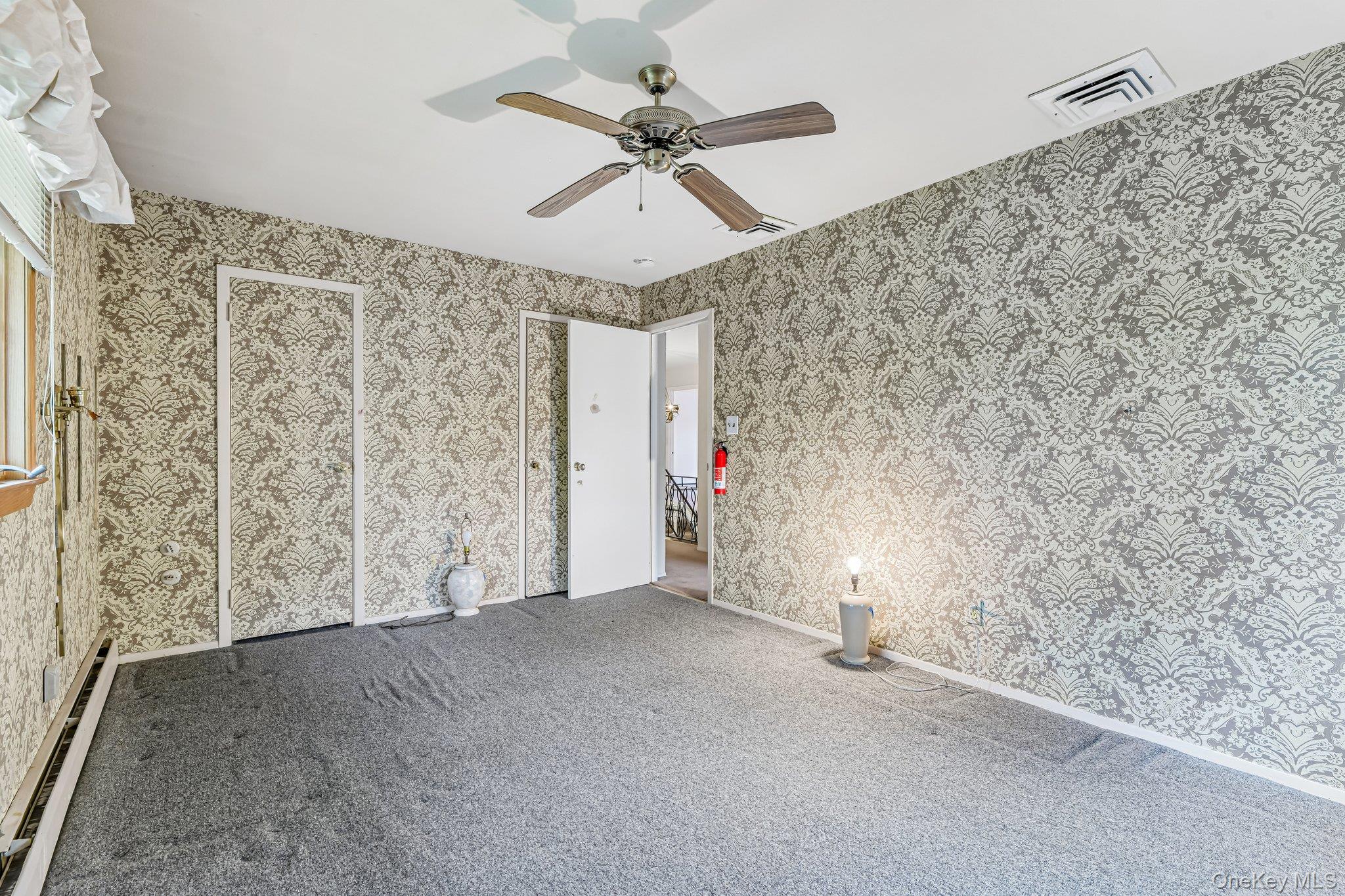 237 Cedar Road East Northport, NY 11731 - Photo 31 of 45 His and hers closets. Ceiling fan. Hardwood floors under carpet.