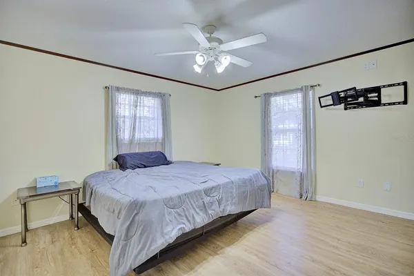 a bedroom with a large bed chandelier and a window