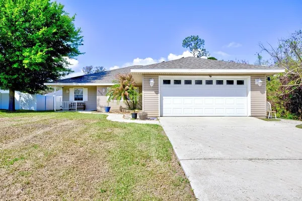 a view of a house with a yard and garage