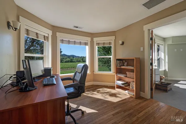 a view of a workspace with furniture and a window