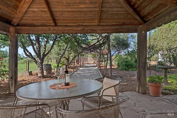 a patio with a table and chairs and potted plants