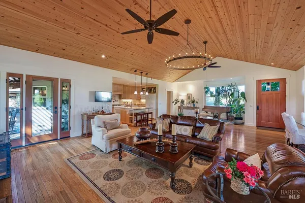 a living room with patio furniture and wooden floor