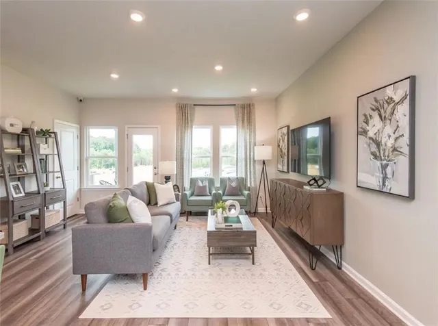 a view of a dining room with furniture a rug and wooden floor