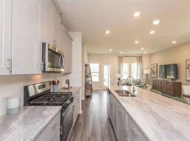a kitchen with stainless steel appliances granite countertop a sink stove and refrigerator