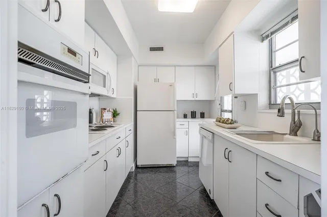 a kitchen with white cabinets and white appliances
