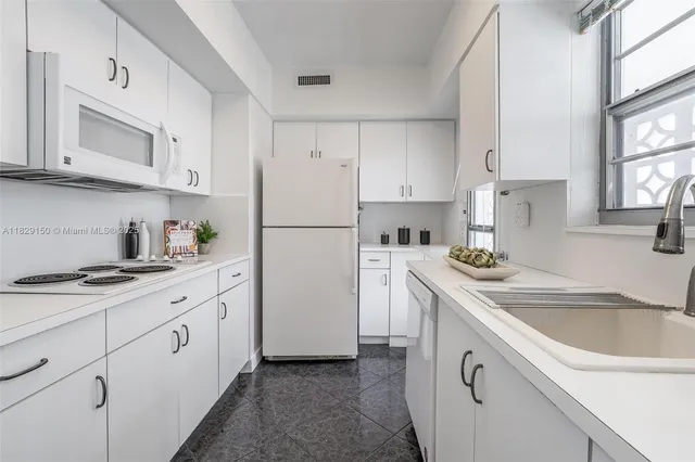 a kitchen with white cabinets sink and white appliances