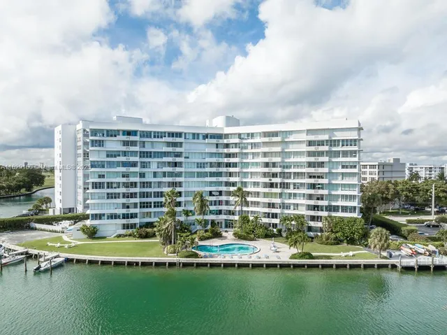 a view of a swimming pool with a yard and plants