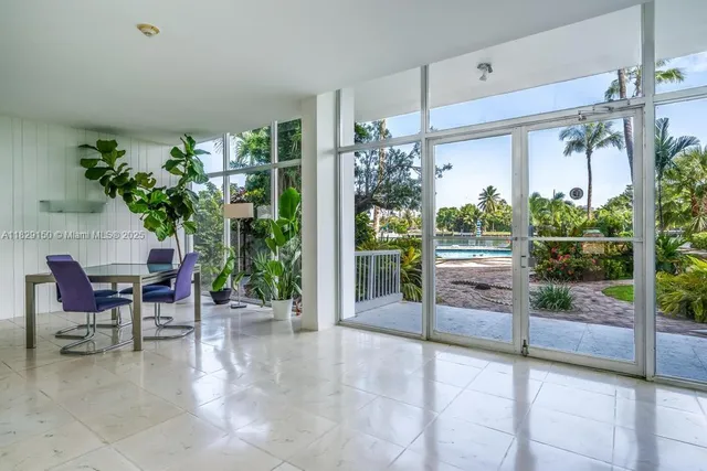 a view of a porch with chairs and potted plants