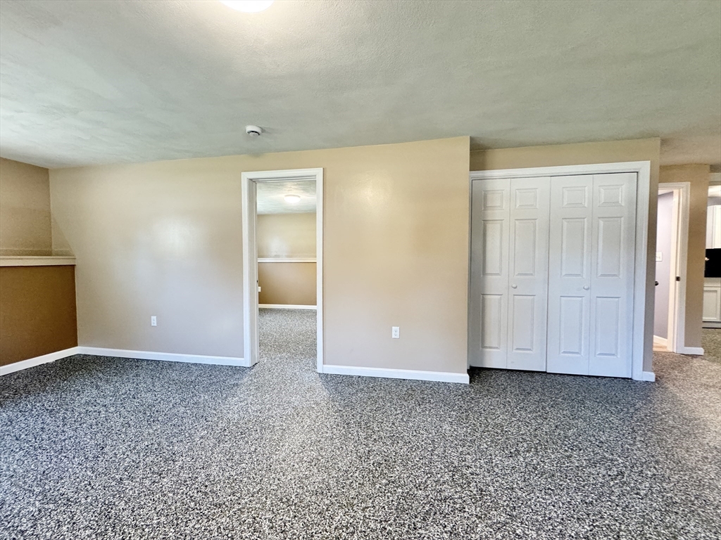 14 Maxdale Road Worcester, MA 01602 - Photo 33 of 42 an empty room with wooden floor and white doors