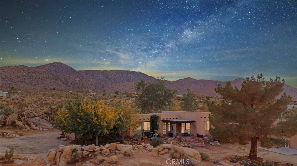 62238 Rincon Road Joshua Tree, CA 92252 - Photo 2 of 60 a view of a big house with a mountain in the background