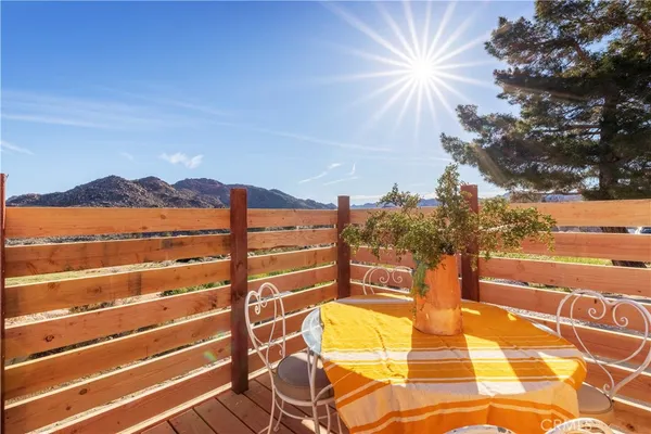 a patio with a table and chairs and potted plants