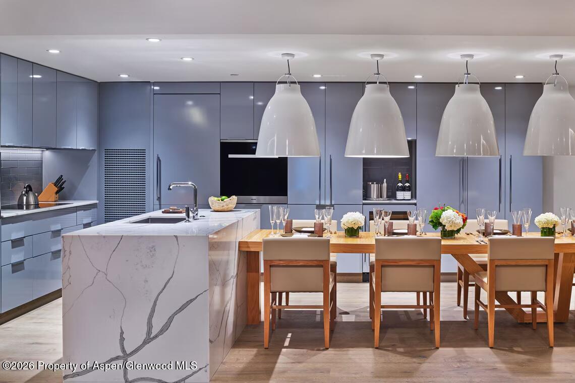 550 South Spring Street, Unit F72 Aspen, CO 81611 - Photo 3 of 16 a kitchen with a table chairs sink and cabinets