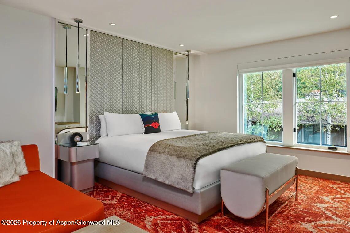 550 South Spring Street, Unit F72 Aspen, CO 81611 - Photo 4 of 16 a bedroom with a bed and glass windows