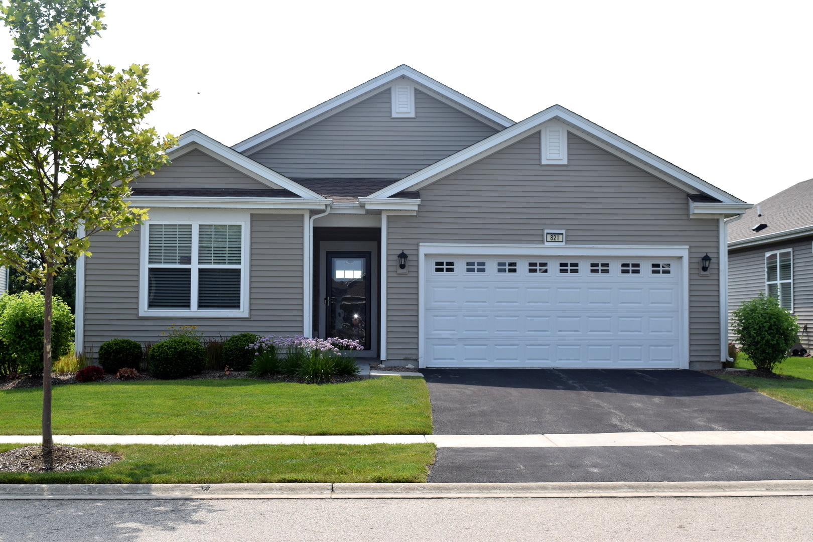821 Americana Avenue Pingree Grove, IL 60140 - Photo 1 of 17 a view of a house with a yard plants and large tree