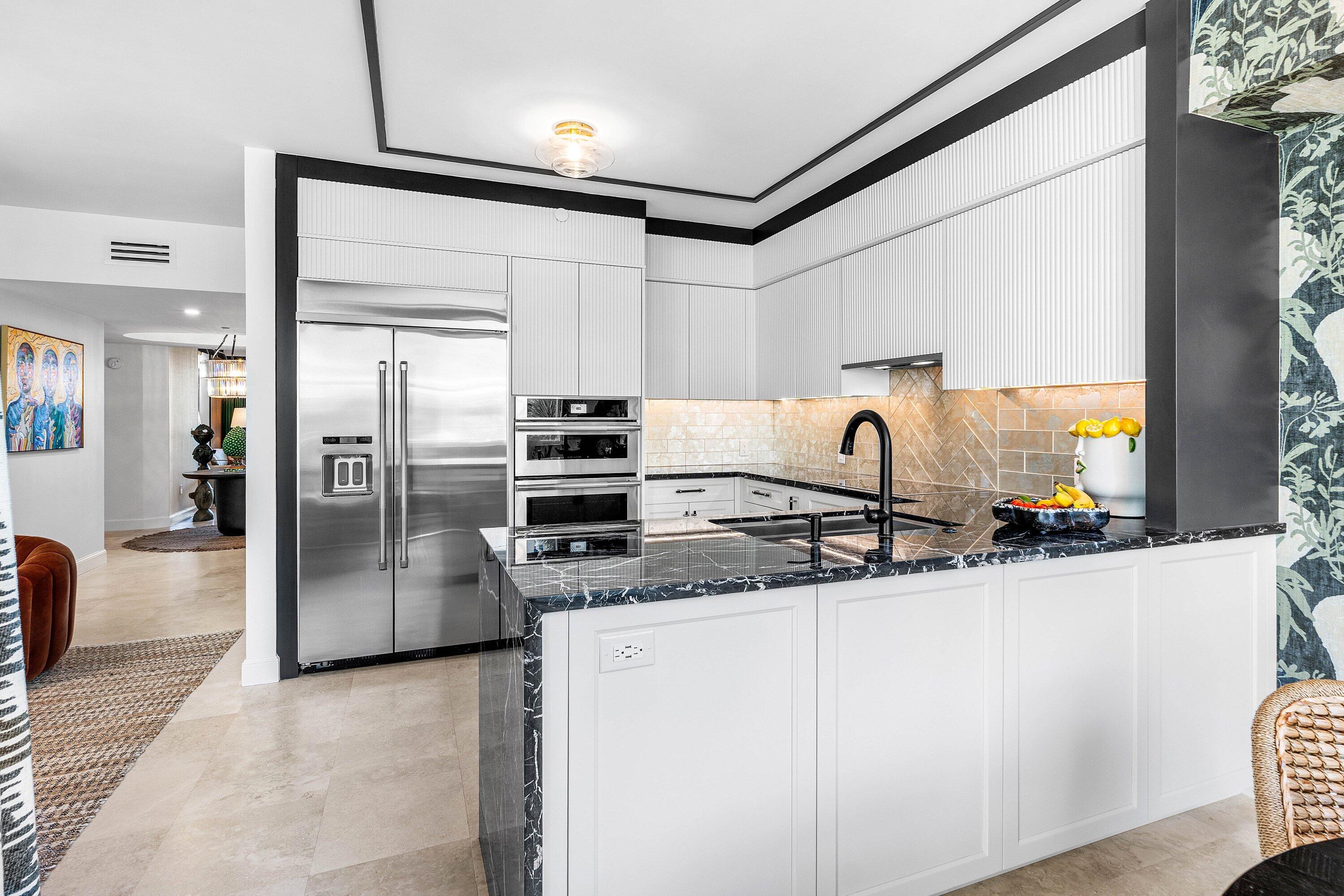 3700 South Ocean Boulevard, Unit 202 Highland Beach, FL 33487 - Photo 20 of 75 a kitchen with stainless steel appliances granite countertop a refrigerator a sink and white cabinets